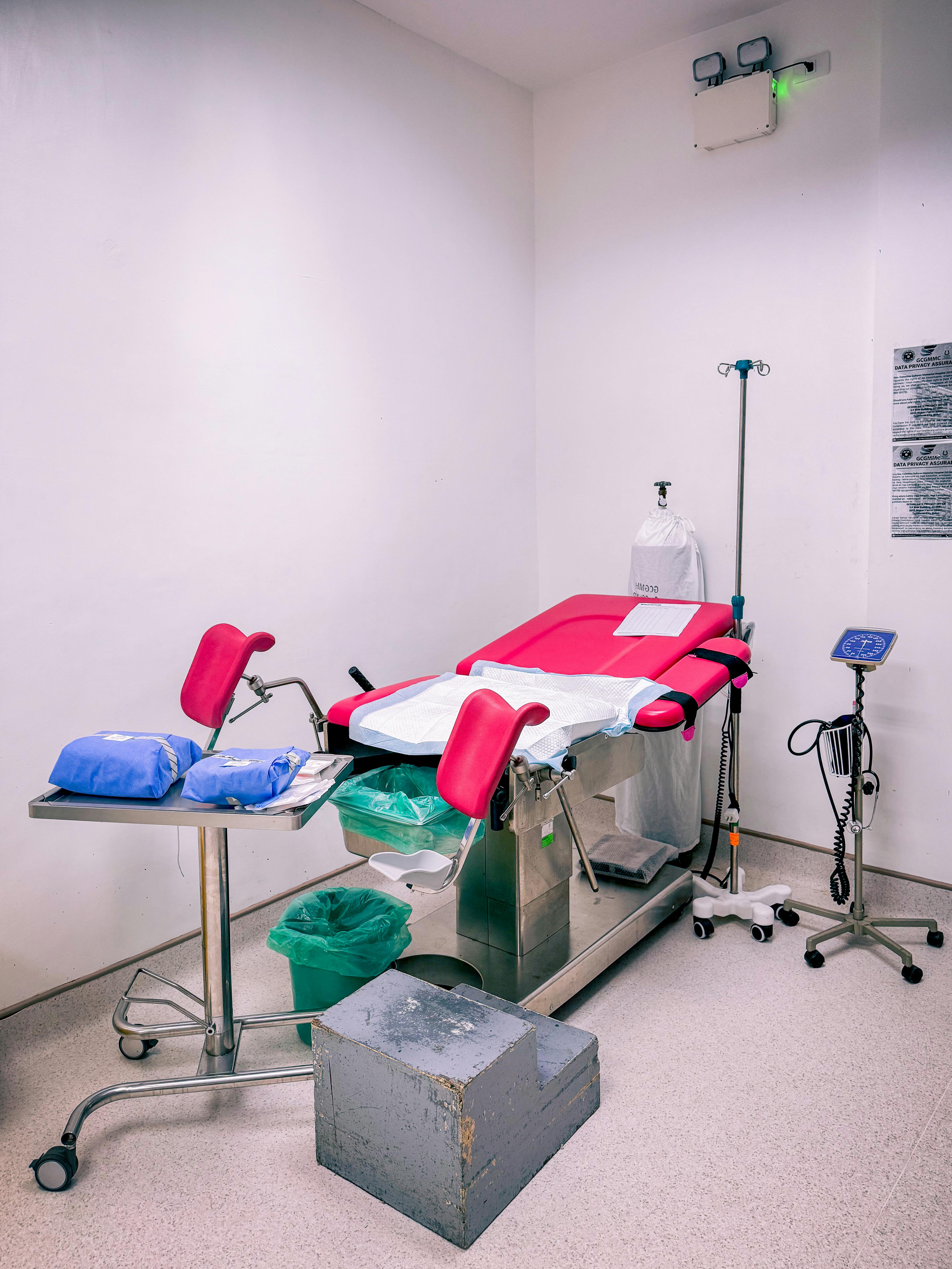 A well-equipped delivery room with a medical bed and equipment in a hospital setting.